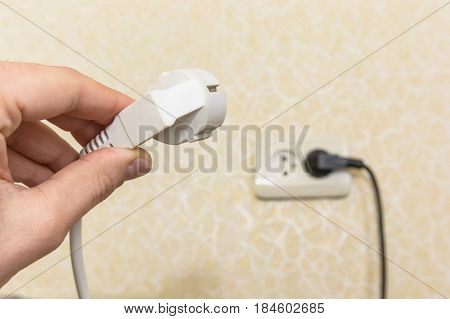 Close-up shot of male hand putting plug into socket