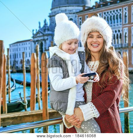 Mother And Child Travellers In Venice Viewing Photos On Camera