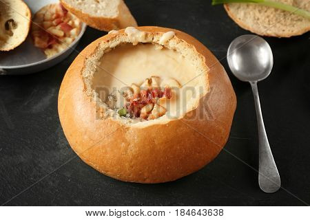 Delicious cream soup in bread on table