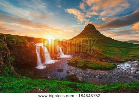 Colorful sunrise on Kirkjufellsfoss waterfall. Amazing morning scene near Kirkjufell volkano, Iceland, Europe.