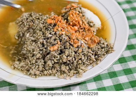 Kupang lontong kuah petis or steamed mussels with rice cake