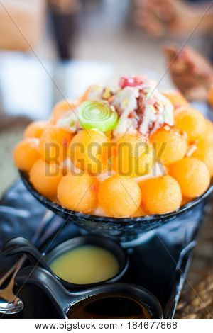bingsu is a Korean shaved ice dessert with sweet toppings such as chopped fruit, condensed milk, fruit syrup, and red beans.