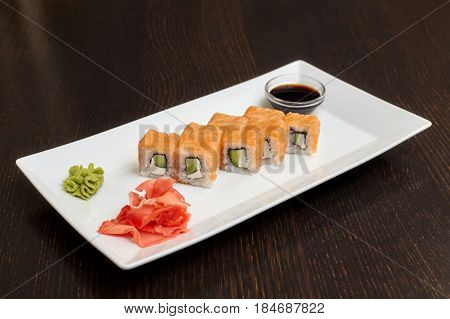 Philadelphia maki sushi rolls with salmon cheese cream and cucumber on white plate