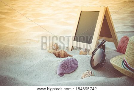 Straw Hat, Sun Glasses, Yellow Ball, Seashell And Blank Blackboard For Text On Clean Sand Beach. Bea