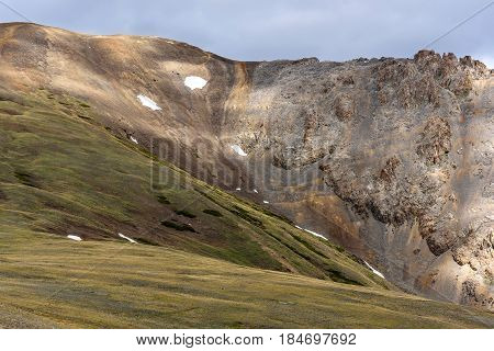 Scenic view with beautiful mountain peaks with snow and rare vegetation on the background of the blue sky and clouds