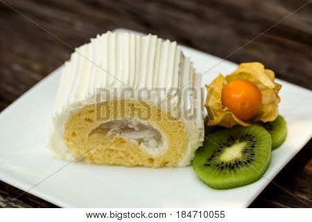 Coconut roll cake with kiwi and cape gooseberry.