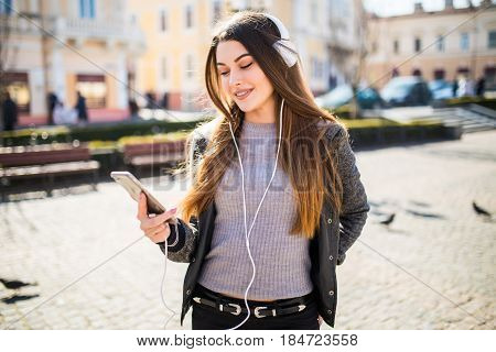 Lifestyle Fashion Portrait Of Young Stylish Hipster Woman Walking On Street Listen Music