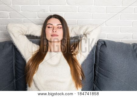 Closeup Of A Smiling Young Woman Lying On Couch At Home