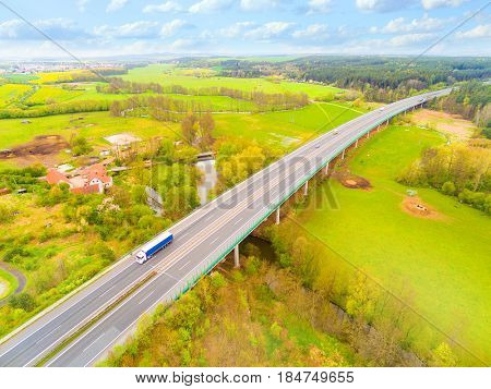 Aerial view of bridge over Radbuza River and green pastures. Highway D5 with traffic near Pilsen, Czech republic, Central Europe. Transportation and sustainable development concept. 

