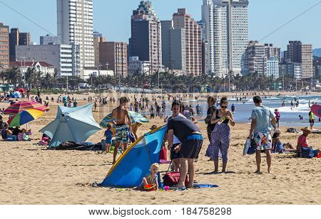 People On Visit To Beach Against Durban City Skyline