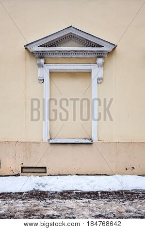 Yellow wall with immured window in winter