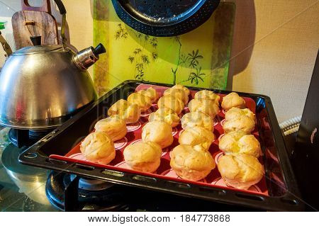 Close up of cooked homemade profiteroles on a tray