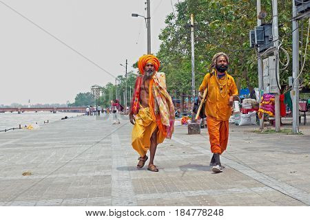 INDIA, HARIDWAR - APRIL 24, 2017: Two sadhus walking along the river Ganges in Haridwar on 24th of april 2017