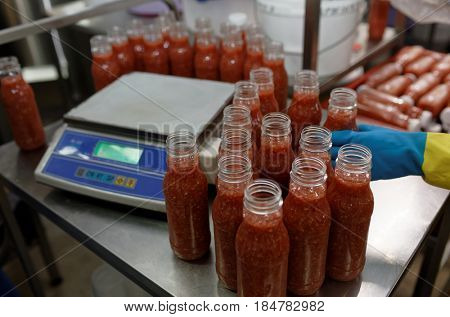 ST. PETERSBURG, RUSSIA - FEBRUARY 28, 2017: Production of ajika sauce in a food processing plant. The Factory of Homemade Pickles participates in the regional quality certification program