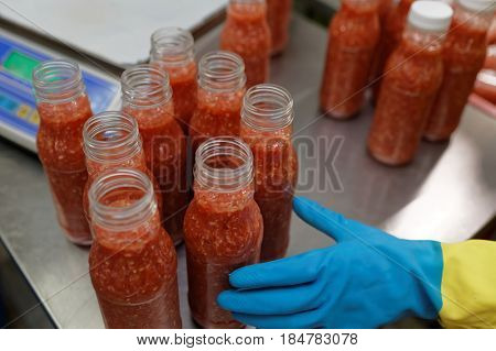 ST. PETERSBURG, RUSSIA - FEBRUARY 28, 2017: Worker packaging ajika sauce in a food processing plant. The Factory of Homemade Pickles participates in the regional quality certification program