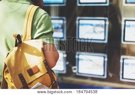 Hipster man with backpack and map looking ad promo poster hotel choose apartments. Tourist traveler planning route on background advert hostel city. Person hiker select hotel backdrop summer street