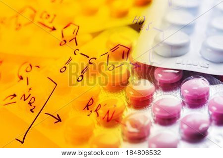 Chemical formulas and tablets in blister packs - pharmaceutical concept