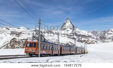 Zermatt, Switzerland - April 12, 2017: The red Gornergrat Train in front of the snowy Matterhorn mountain