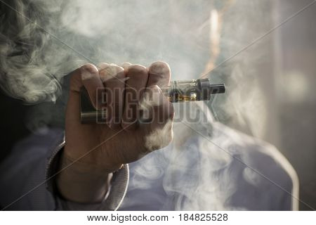 Man Vaping Electronic Cigarette With Clouds.