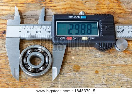 Digital caliper with ball bearing on a wooden table