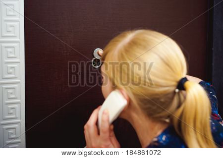 Blonde Woman Answers The Intercom Call, Hold The Phone To His Ear, Waiting For The Arrival Of The Lo