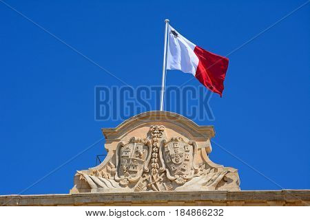 The coat of arms of Castille and Leon and Maltese flag on top of the Auberge de Castille (office of the Prime Minister) in Castille Square Valletta Malta Europe.