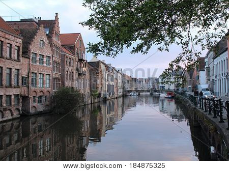 GENT, BELGIUM, APRIL 07 2017: Evening view of the water and historic buildings from the Kraanlei in Gent. Gent has a historic city centre and is a hugely popular tourist destination in East Flanders.