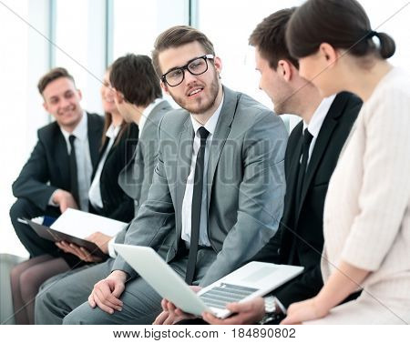 business team with laptop and documents sitting in the lobby bef