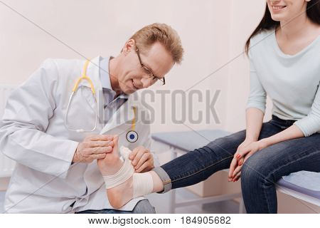 How did you do that. Scrupulous delicate distinguished rheumatologist putting a bandage on patients ankle joint after she damaging it and coming to him for consultation