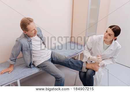 Is it ok like this. Trained competent capable rheumatologist conducting an experiment for checking mans reflexes and finding the cause of pain