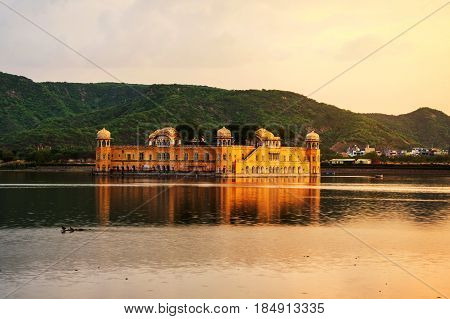 Jaipur, India. Jal Mahal palace at sunset in Jaipur, India. Popular landmark surrounded by water. Mountains at the background
