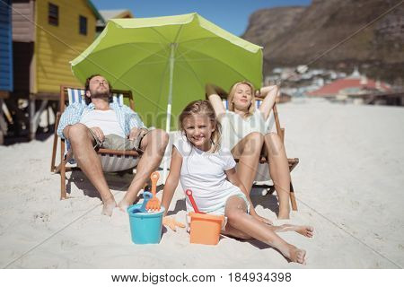 Family relaxaing at beach during sunny day