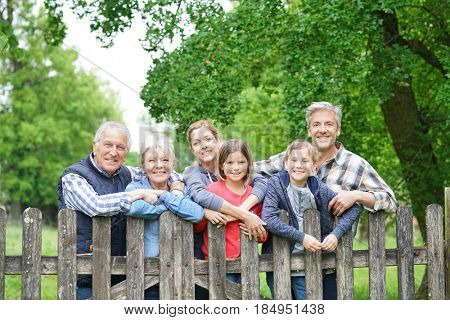 Portrait of happy family leaning on fence