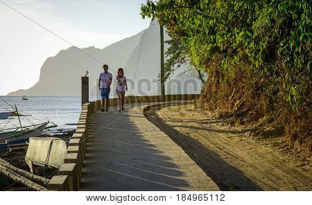 People Walking On Road With The Sea
