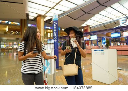 SINGAPORE - CIRCA AUGUST, 2016: young women at Singapore Changi Airport Terminal 2 departure hall