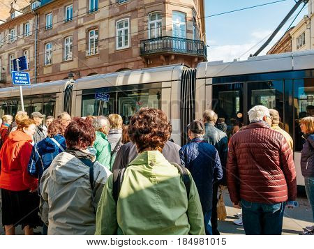 STRASBOURG FRANCE - APR 27 2017: Group of senios tourists waiting for hte tramway to pass to discover the French city of Strasbourg Alsace