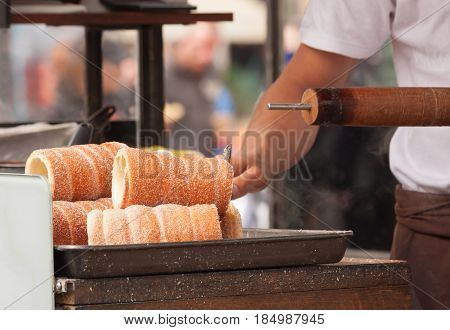 Trdelnik - traditional Czech hot sweet pastry baked on a stick and sold in the streets of Prague