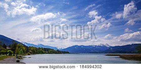 Panoramic view to lake tegernsee bavarian tourist resort with the alps in the background on a sunny spring day with cloudy blue sky bavaria germany europe copy space