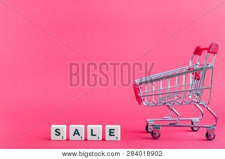 Empty Grocery Cart And Word Sale On Pink Background. Trolley From A Supermarket. Online Shopping Con