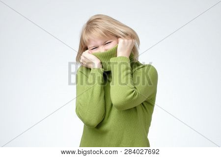 Girl Pulling Her Trendy Green Sweater Over Head Having Fun.