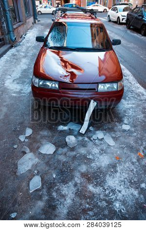 Broken Windshield And Car Bonnet Of Car After Falling A Piece Of Ice (block Of Ice) From The Roof Of
