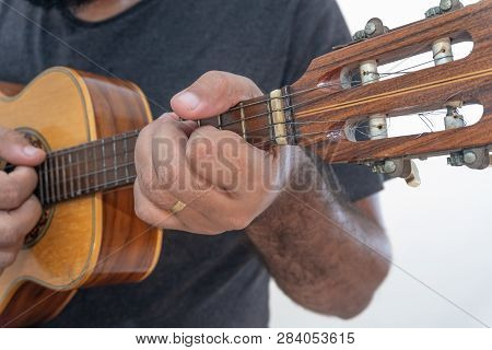 Young Man Playing Ukulele With Shirt And Black Pants.