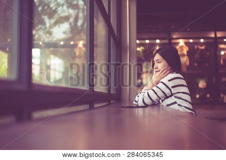 Asian Beautiful Woman Sittiing And Looking Something Out Of Window At Coffee Shop Cafe,happy And Smi