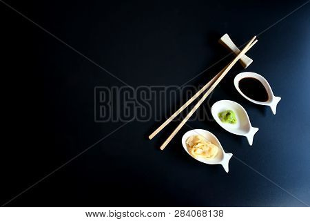 Close Up Top View Accessories With Chopstick And Small Plate With Sauces For Sushi On Black Backgrou