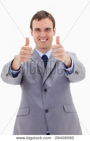 Thumbs up dato dall'uomo d'affari sorridenti contro uno sfondo bianco
