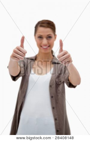 Thumbs up dato da donna sorridente contro uno sfondo bianco