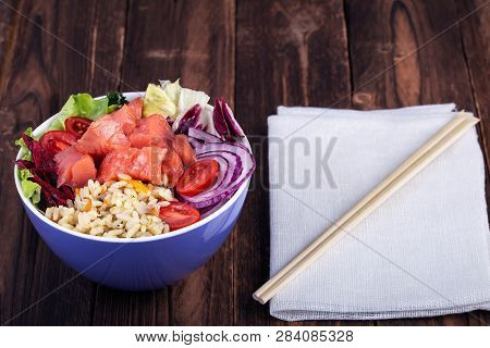 Poke Bowl Trand. Raw Fish, Rice And Halhy Vegetables On Wooden Background