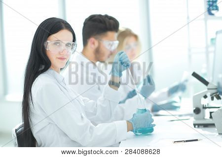 Close Up.modern Woman Sitting With Colleagues At The Laboratory Table.