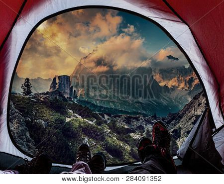 Night bivouac in Dolomites, milion star hotel under night sky, red illuminated tent on pass in Dolomites, Italy.
