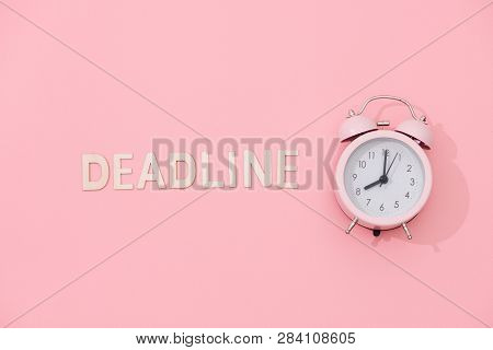 Deadline Text With Light Pink Retro Alarm Clock With Shadow On Pink Background.